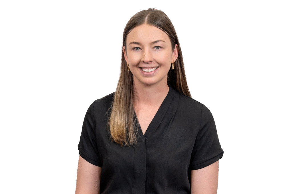 A young woman with straight, light brown hair smiles at the camera. She is wearing a short-sleeved black blouse and gold hoop earrings, posed against a plain white background—an inspiring face in music therapy courses on the Gold Coast.