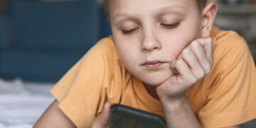 Sad boy looking at phone